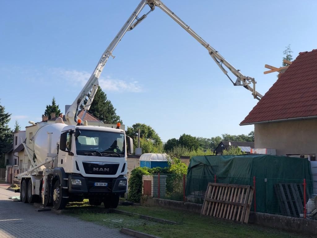 Autodomíchávač s čerpadlem betonu zapatkovaný u rodinného domu