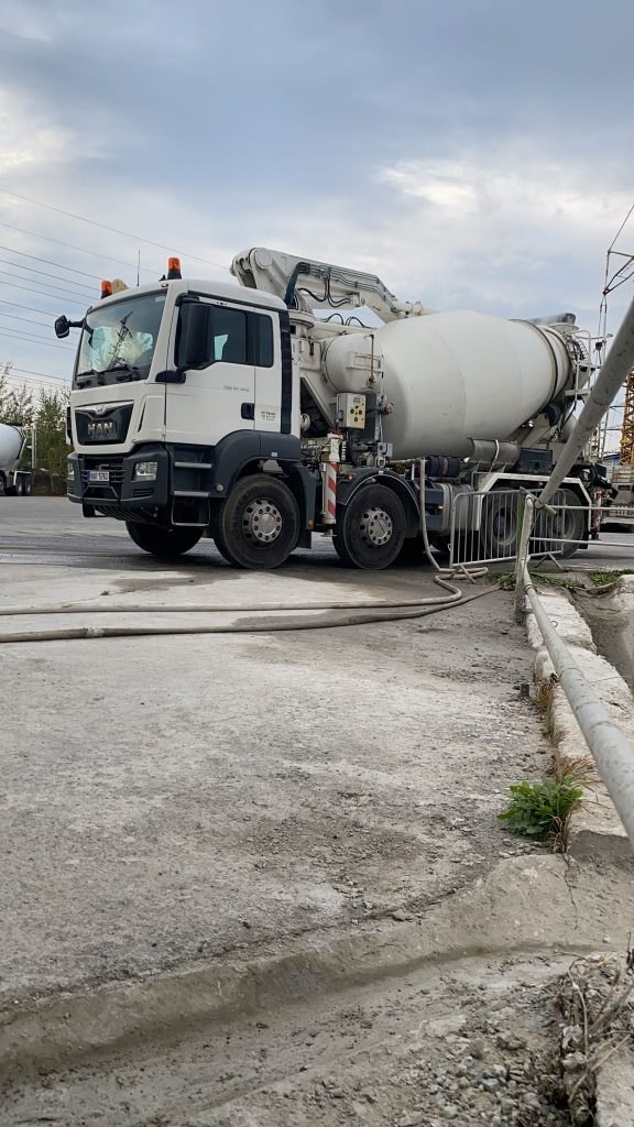 Autodomíchávač MAN s hadicí na vybetonované ploše